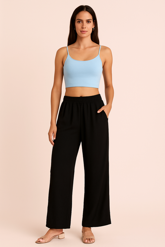 Woman wearing black ankle-length rayon plazzo pants with elastic waistband and loose fit.
